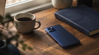 机に置かれたスマートフォンとコーヒー